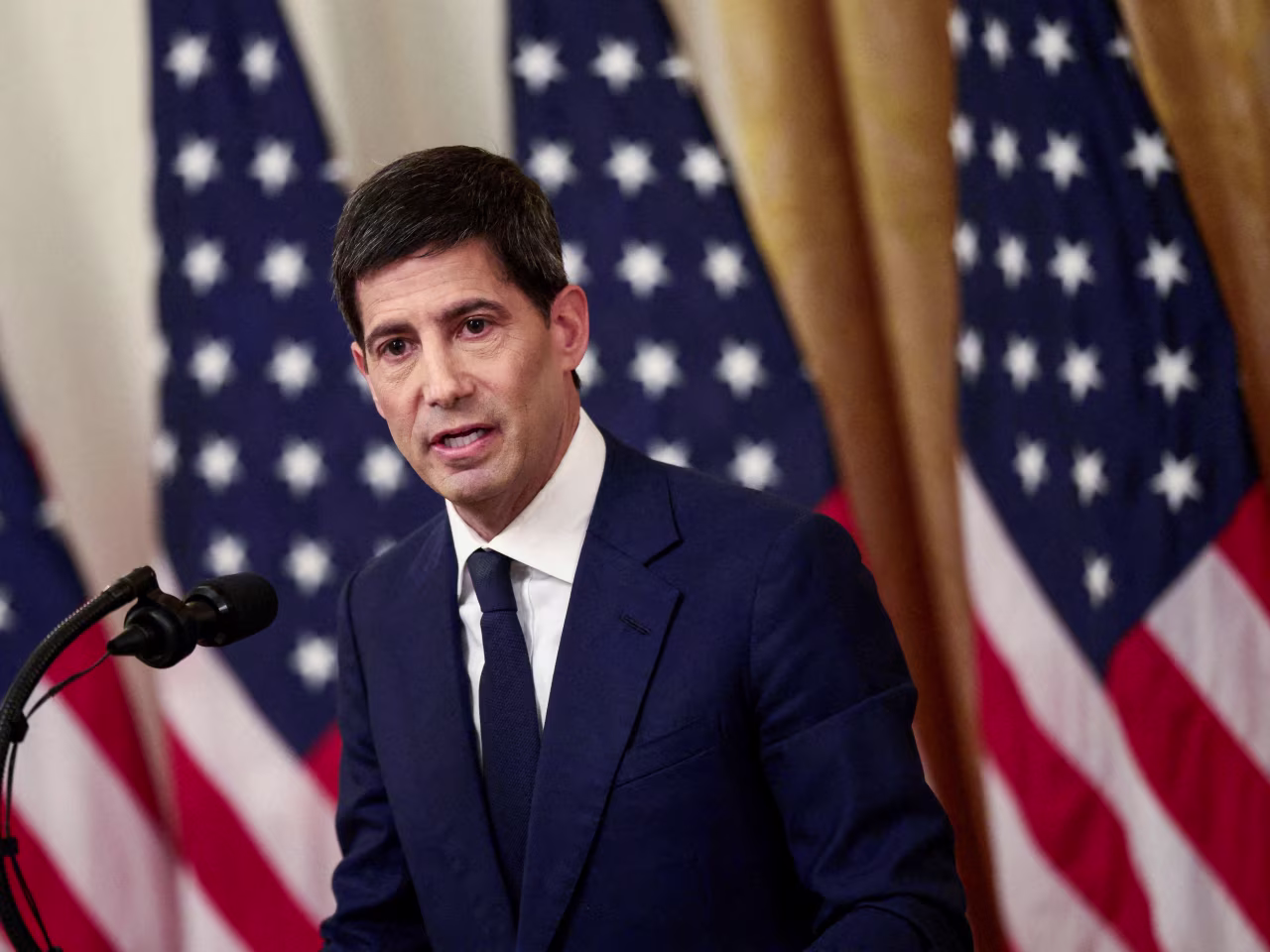 Kevin Warsh 在新聞發布會或會議上發言,背景有美國國旗,2026 年 6 月聯邦儲備